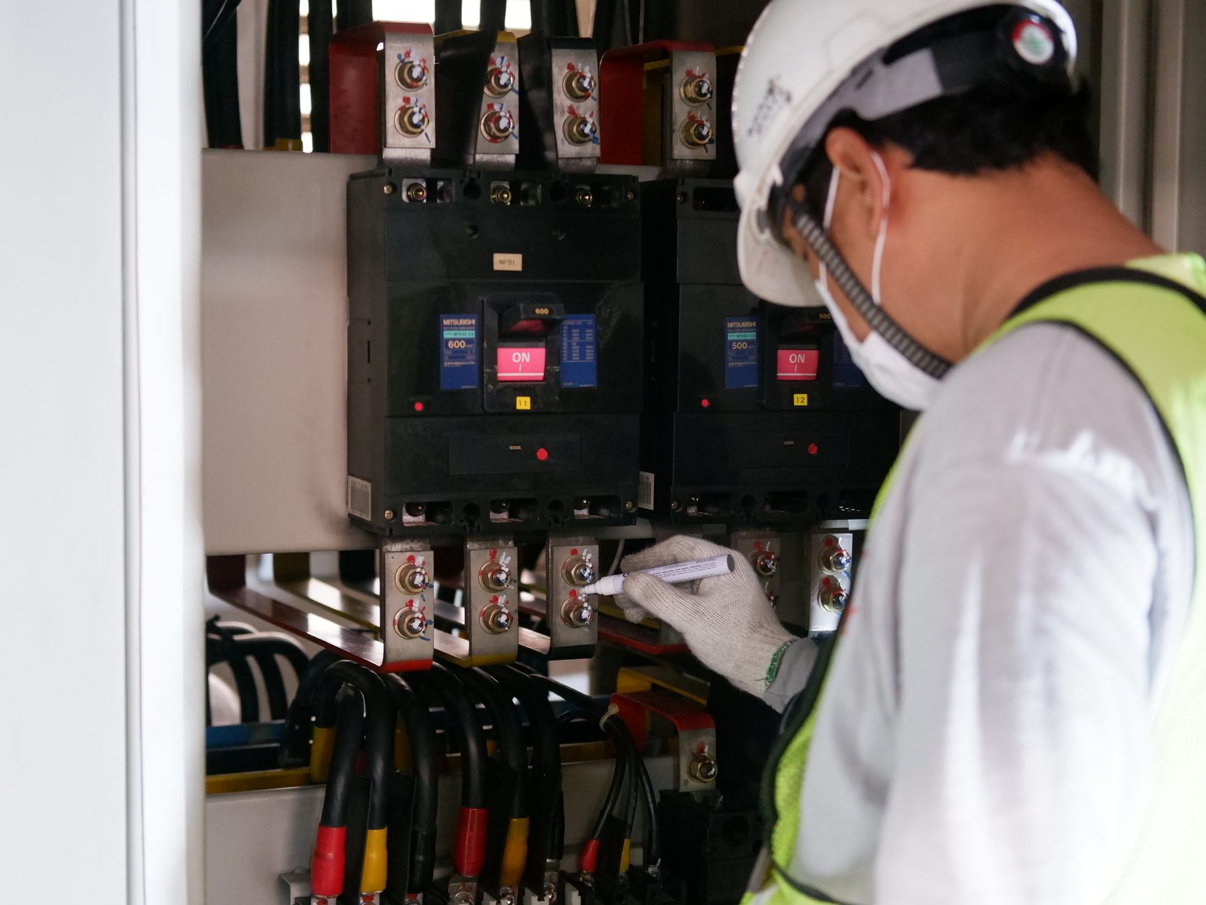 Technikus elektromos elosztópanelt ellenőriz ipari környezetben
